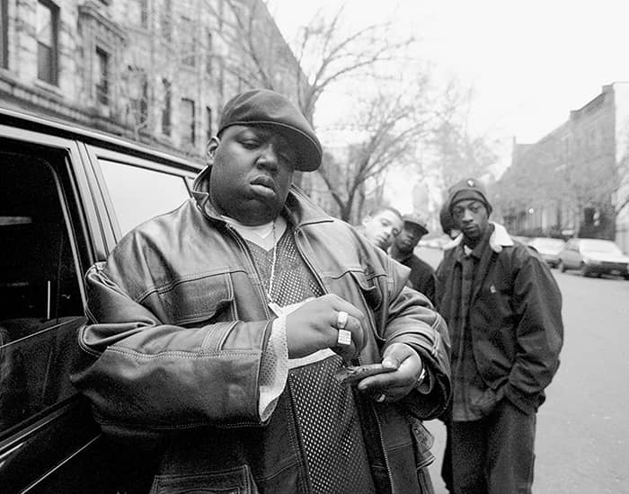 American rapper Notorious B.I.G., aka Biggie Smalls, aka Chris Wallace (1972 - 1997), rolls a cigar outside his mother's house in Brooklyn, New York, 18th January 1995.