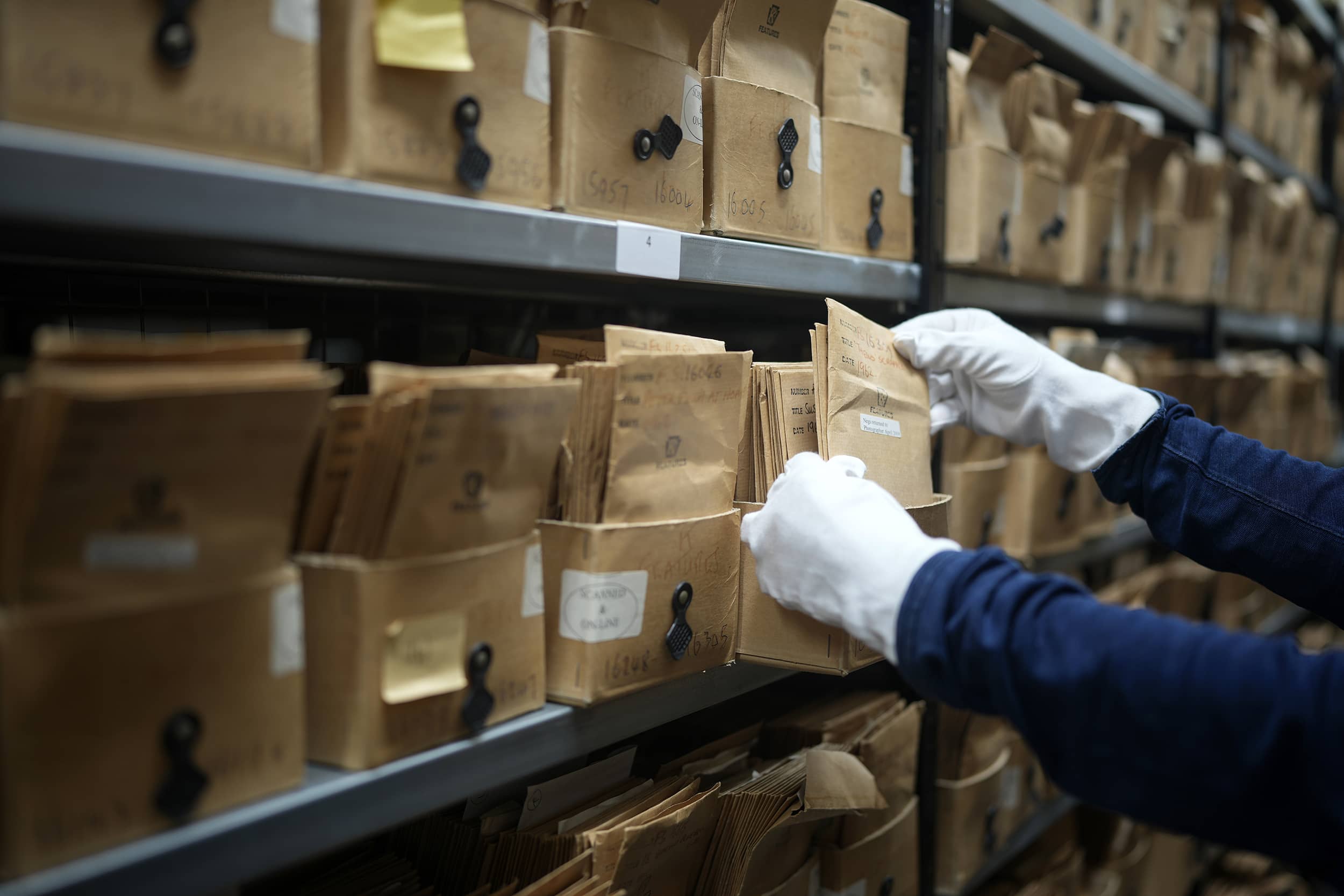 A curatorial assistant working with boxes of negatives and story captions from the Keystone Features collection, at the Getty Images Hulton Archive, London E16, 12th September 2023